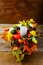 Thanksgiving centerpiece with candle and artificial fall leaves Royalty Free Stock Photo
