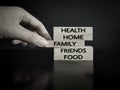 Thanksgiving concept. Health,home,family,friends,food text on wooden blocks with hand background