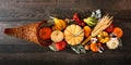 Thanksgiving cornucopia filled with autumn vegetables and pumpkins, above against dark wood Royalty Free Stock Photo