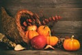 Thanksgiving cornucopia with pumpkins and apples against wood