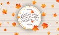 Thanksgiving Day card. Give Thanks calligraphy and falling autumn leaves on wooden background. Thanksgiving Day banner