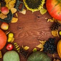 Thanksgiving day composition of vegetables, sunflower, apple and fall leaves on wooden background. Flat lay Royalty Free Stock Photo