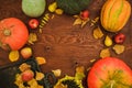 Thanksgiving day composition of vegetables, sunflower, apple and fall leaves on wooden background. Flat lay, top view. Autumn dinn