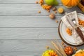 Thanksgiving day concept. Top view photo of table setting plate knife fork napkin vegetables pumpkins pear wheat walnut rowan