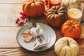 Thanksgiving day serving table with plate, taleware, pumpkins and leaves on wooden background Royalty Free Stock Photo