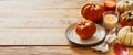 Thanksgiving day serving table with plate, taleware, pumpkins and leaves on wooden background Royalty Free Stock Photo