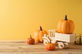 Thanksgiving decor concept with toy truck and pumpkin decor on wooden table over yellow background. Autumn season greeting card Royalty Free Stock Photo