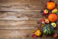 Thanksgiving decor with green pumpkin, orange onion squash, fall leaves, apples and pears on the rustic wooden background, copy Royalty Free Stock Photo