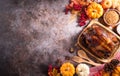 Thanksgiving dinner background concept with turkey roasted and all sides dishes, fall leaves, pumpkin and seasonal autumnal decor