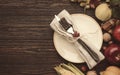 Thanksgiving dinner place setting. Autumn fruit, pumpkins, nuts, fallen leaves with plate and cutlery. Thanksgiving autumn Royalty Free Stock Photo