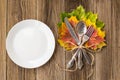 Thanksgiving dinner plate with fork, knife and autumn leaves on rustic wooden table background. Top view, copy space Royalty Free Stock Photo