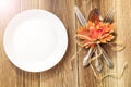 Thanksgiving dinner plate with fork, knife and autumn leaves on rustic wooden table background. Top view, copy space Royalty Free Stock Photo