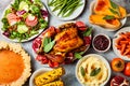 Thanksgiving dinner table with roasted whole chicken or turkey, green beans, mashed potatoes, cranberry sauce, grilled vegetables Royalty Free Stock Photo