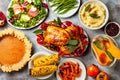 Thanksgiving dinner table with roasted whole chicken or turkey, green beans, mashed potatoes, cranberry sauce, grilled vegetables Royalty Free Stock Photo