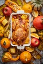 Thanksgiving dinner table with roasted whole chicken or turkey, pumpkin, baked potatoes, chestnuts