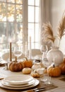 Thanksgiving dinner table served with pumpkins in handcrafted style with white and light beige contemporary ceramics. Candles