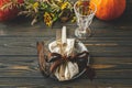 Thanksgiving dinner table setting. Stylish plate with cutlery and autumn decorations, pumpkin, natural branches and autumnal Royalty Free Stock Photo