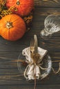 Thanksgiving dinner table setting. Stylish plate with cutlery, linen napkin and pumpkin with autumnal flowers on rustic table. Royalty Free Stock Photo