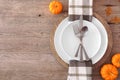 Thanksgiving or fall harvest table setting, top view, side border against a wood background
