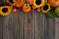 Thanksgiving framework. Flowers, pumpkins and fallen leaves on wooden background. Copy space for text. Halloween Royalty Free Stock Photo