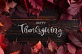 Thanksgiving greetings. Dry red leaves on a wooden background, top view. Kaligraphic capital inscription Royalty Free Stock Photo