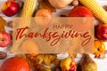 Thanksgiving greetings. Pumpkins, vegetables, nuts, dry leaves on a wooden background, top view. Kaligraphic capital inscription Royalty Free Stock Photo