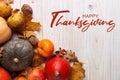 Thanksgiving greetings. Pumpkins, vegetables, nuts, dry leaves on a wooden background, top view. Kaligraphic capital inscription Royalty Free Stock Photo