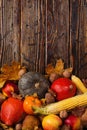 Thanksgiving greetings. Pumpkins, vegetables, nuts, dry leaves on a wooden background, top view. Kaligraphic capital inscription Royalty Free Stock Photo