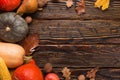 Thanksgiving greetings. Pumpkins, vegetables, nuts, dry leaves on a wooden background, top view. Kaligraphic capital inscription Royalty Free Stock Photo