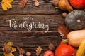 Thanksgiving greetings. Pumpkins, vegetables, nuts, dry leaves on a wooden background, top view. Kaligraphic capital inscription Royalty Free Stock Photo