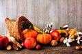 Thanksgiving harvest cornucopia filled with autumn fruits and vegetables against grey wood Royalty Free Stock Photo