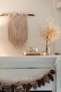 Thanksgiving Home  Decor - White Wooden Fireplace With Wall Macrame, Cream And Beige Pumpkins, Pine Cones Garland And Rustic Dry