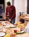 Thanksgiving, man and child in living room together for serving food, eating and dining table in family home. Dinner Royalty Free Stock Photo