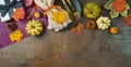 Thanksgiving party banner concept with plate, pumpkin and autumn leaves on dark background. Top view, flat lay