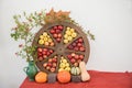 Thanksgiving table with pumpkins, wheel with ripe apples and rose hip twig in a green vase Royalty Free Stock Photo