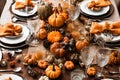 Thanksgiving table setting with automnal decorations, pumpkins, glasses and plates. Holidays, catering and hospitality concept.