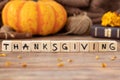 Thanksgiving text word on wooden cubes with autumn leaves, pumpkin, and Holy Bible Book in the background, closeup Royalty Free Stock Photo