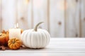 Thanksgiving white pumpkin and candle decorations on a white painted wood table. Halloween, Thanksgiving party concept