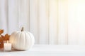 Thanksgiving white pumpkin and candle decorations on a white painted wood table. Halloween, Thanksgiving party concept