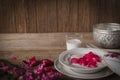 Thapthim krop, mock pomegranate seeds in coconut and syrup in the white bowl on the wood table there are flower, spoon, coconut