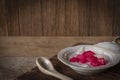 Thapthim krop, mock pomegranate seeds in coconut and syrup in the white bowl on the wood table there is spoon ceramic placed in