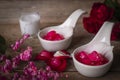 Thapthim krop, mock pomegranate seeds in coconut and syrup in the white spoon bowl on the wood table there are flower, same spoon