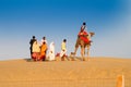 Tourists riding camels, Camelus dromedarius, at sand dunes of Thar desert. Royalty Free Stock Photo