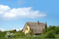 Thatched cottage in the green countryside against a blue sky, ty Royalty Free Stock Photo