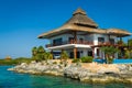 Thatched house on the rocks by the sea Royalty Free Stock Photo