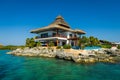 Thatched house on the rocks by the sea Royalty Free Stock Photo