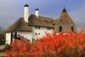 Thatched roof house in autumn. Cottage in rustic style in leaf fall. Rural landscape.Tourism and recreation in countryside Royalty Free Stock Photo