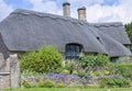 Thatched roof house with garden in bloom in idyllic english village . Royalty Free Stock Photo