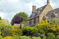 Thatched roof house with garden in bloom in idyllic english village . Royalty Free Stock Photo