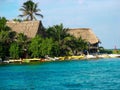 Large thatched roof huts on Glover`s Atoll, Belize